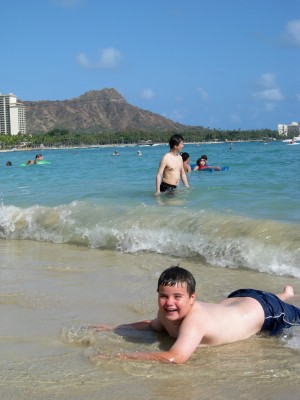 A happy kid (mine) in the Waikiki surf, Hawaii (photo by Sheila Scarborough)