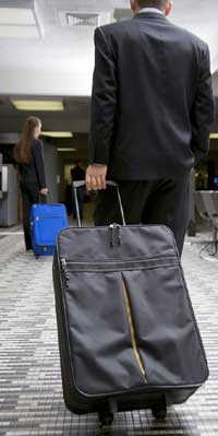Man rolling airport suitcase