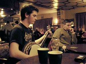 The banjo player closes his eyes in concentration at the Green Olive traditional Irish session in Athlone