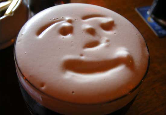face drawn in the top of guinness stout