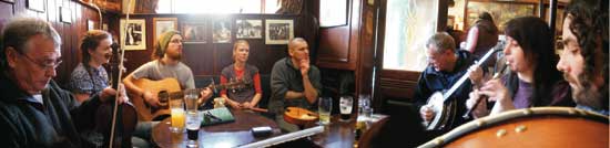 musicians sit around the table at Sean's Bar Sunday session in Athlone