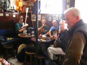 an old man sings an irish song in sean's bar, athlone as the sunday session players look on