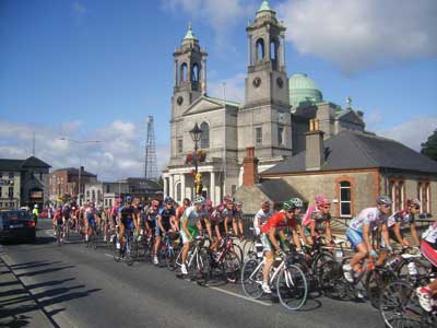 bicyclists in the tour of ireland race pass athlone's saints peter and paul's church